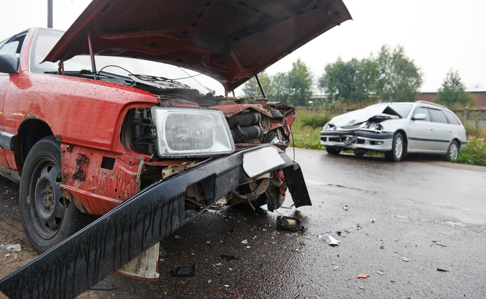 Damaged cars on city street after collision, illustrating car crash accident and its aftermath.