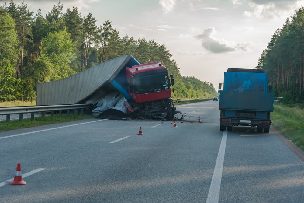  A truck has rolled over on the road, causing a  crash.






