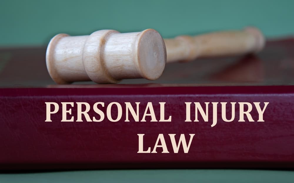 PERSONAL INJURY LAW - words on a burgundy folder on the background of a judge's gavel