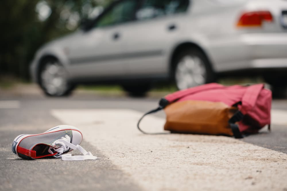 Child's shoe and knapsack on a pedestrian crossing after a collision with a car